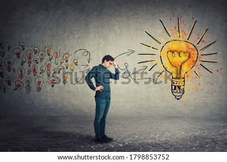 Side view full length, pensive man keeps hand to forehead, hard thinking for the best solution. Ingenious business person or student gathering new ideas into a big lightbulb. Genius creativity concept Foto stock © 