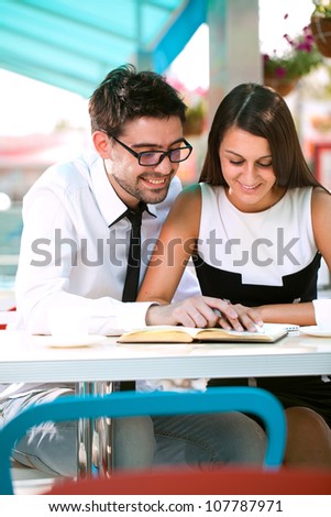 Two reading a book in a cafe