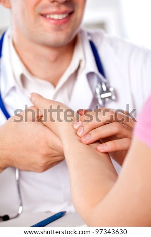 physician measures the pulse of the patient