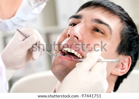 a man with an open mouth and dental mirror