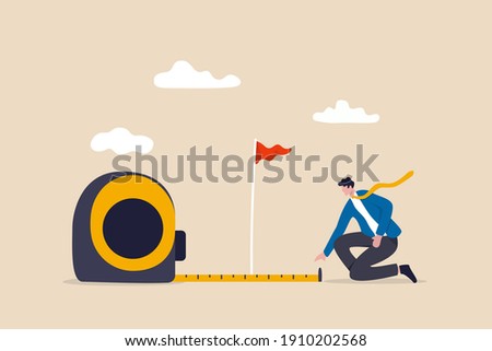 Business success measurement, how far from business goal and achievement or growth metric analysis concept, smart businessman using measuring tape to measure and analyze distance from target flag.