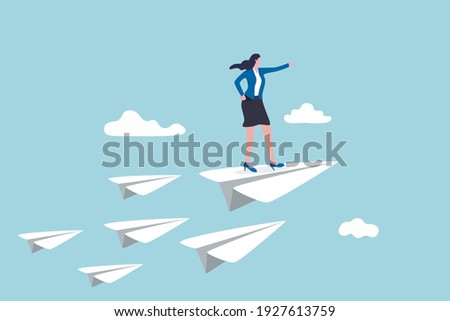 Business leadership, woman power to lead company to achieve target, smart confidence businesswoman standing on leading flying paper airplane origami pointing finger to the direction to reach goal.
