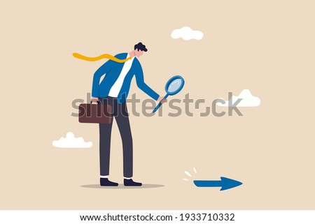Searching for business direction, strategy or discover business opportunity or solution for work difficulty concept, businessman leader using magnifying glass to discover arrow on the floor.