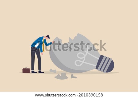 Uninspired or motivation after business failure, burnout or exhausted from crisis, no new idea or inspiration concept, depressed business man sadly standing with fail old broken lightbulb idea.