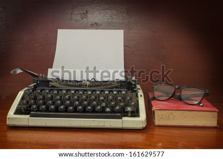 Typewriter with book and eyeglasses.