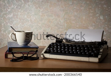 Typewriter with coffee cup,book and eyeglasses.