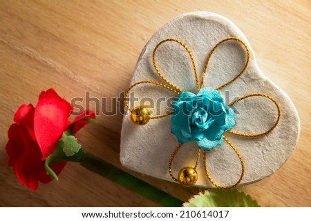 Present box with artificial flower.