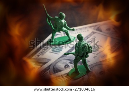 Soldier toys on money with fire screen.
