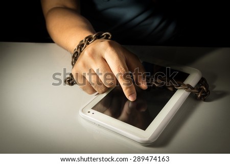 Computer tablet and human hand locked by chain.