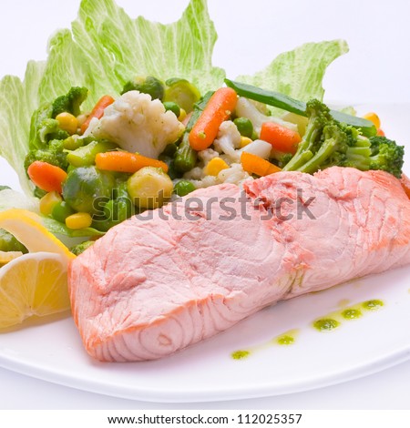 Red fish with boiled vegetable on white plate