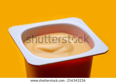 Caramel yogurt  in brown plastic box on yellow background
