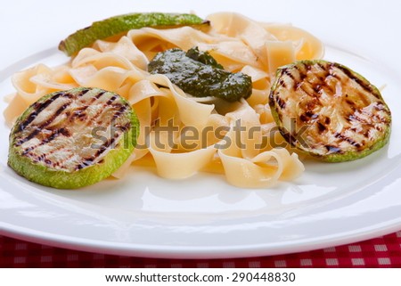 Closeup grilled zucchini round with noodles