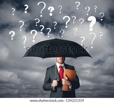 A businbessman protects himself by doubts with umbrella