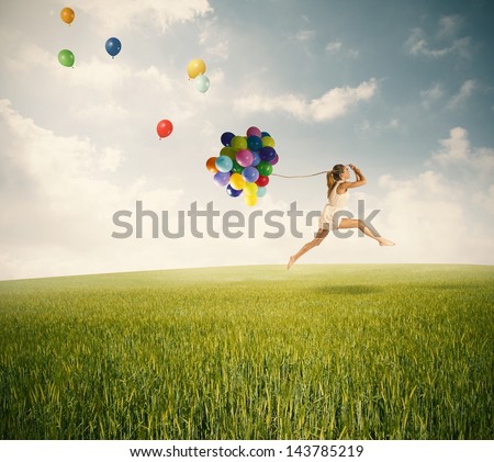 Jumping with balloons in a green field
