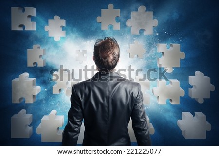 Businessman looking for the solution of the puzzle