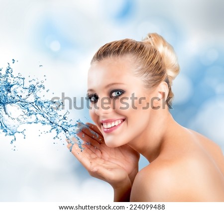 Beautiful woman with splashes of water in hands