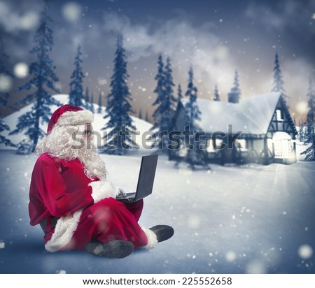 Santa Claus surfs on internet with a laptop