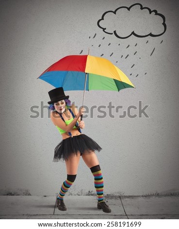 Clowns with rainbow umbrella sheltering from rain