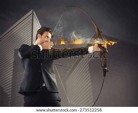 Determinated businessman with flaming arrow takes aim