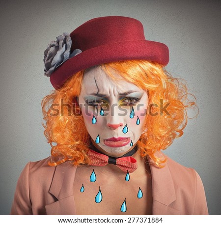 Theatrical sad and depressed girl clown crying