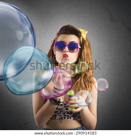 Girl playing at colored bubbles of soap