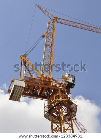 Isolated luffing jib tower crane against blue sky