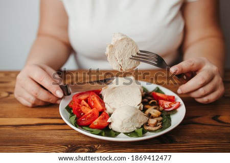 Diet concept, healthy lifestyle, low calorie food, low carb diet. Fat woman eating baked chicken breasts with salad, close up