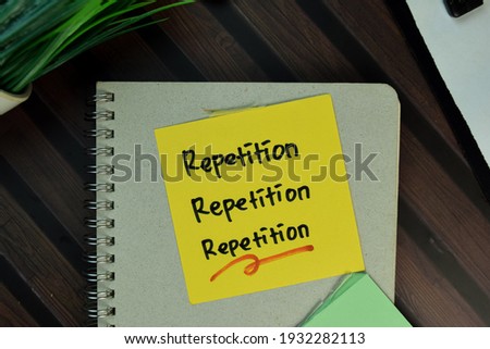 Repetition, Repetition, Repetition write on sticky notes isolated on Wooden Table. Selective focus on Repetition text