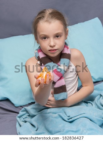 school-age child is recovering from an illness and holds slices of mandarin
