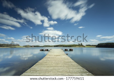 Wooden pier on lake in north Poland. Long exposure and motion in sky/Wooden pier long exposure