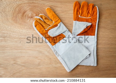 leather work gloves on brown wood background