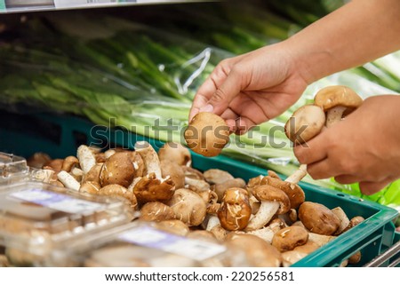 Hand holding vegetable in department store