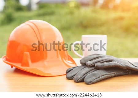 Close up coffee cup and safety helmet on the table