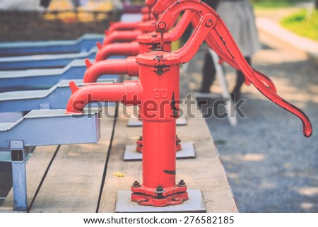 Close up red retro style hand water pump