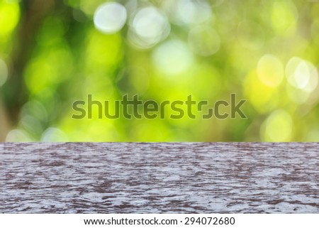 Close up top stone table with sunny abstract green nature background, blurred bokeh