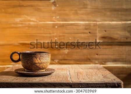 Close up palm wood coffee cup on wooden table and wooden wall