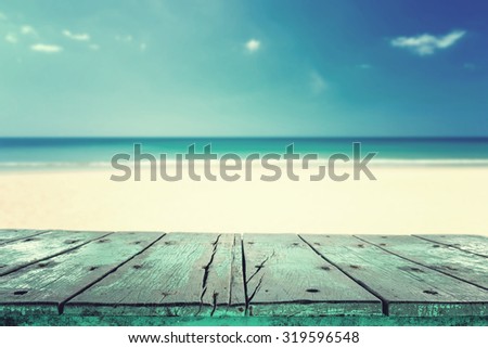 Empty top of wooden table or counter and view of tropical beach. For product display, vintage filter effect