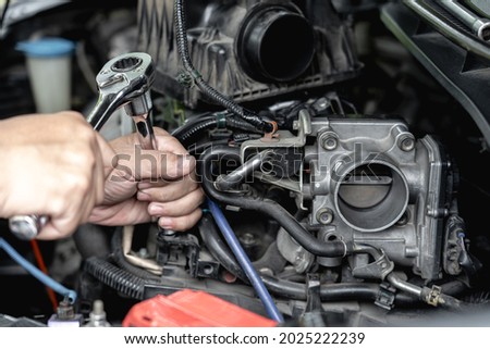 Close up wrench in hand a man  remove bolt of engine in car service engine throttle valve cleaning and maintenance : car service concept photo ストックフォト © 