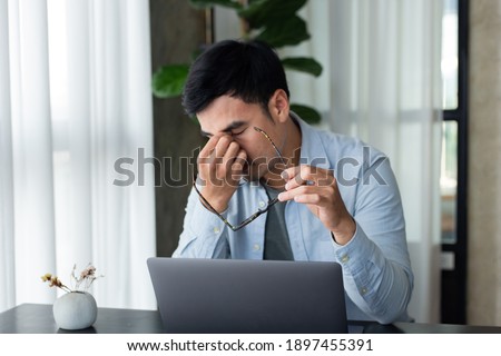 sad depression serious people from work,study stress concept.asian man feeling tired suffering using computer working work place.concept global economic,health problems