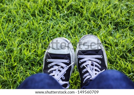 Male feet  feet standing on green grass. it\'s fortable in green lawn.