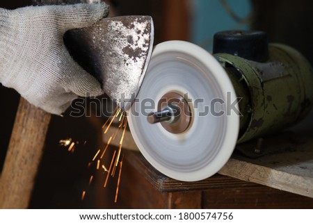 Similar – Image, Stock Photo Worker sharpening axe with electric grinder