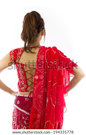 Rear view of a young Indian woman standing with her arms akimbo