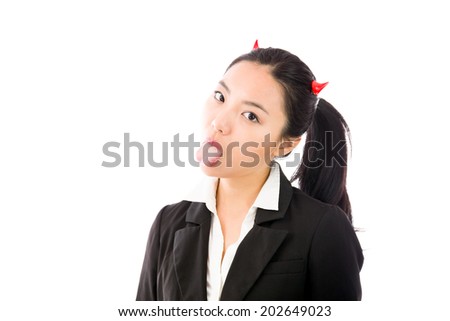 Devil side of a young Asian businesswoman sticking out her tongue isolated on white background