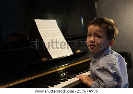 Portrait of a little boy learning piano