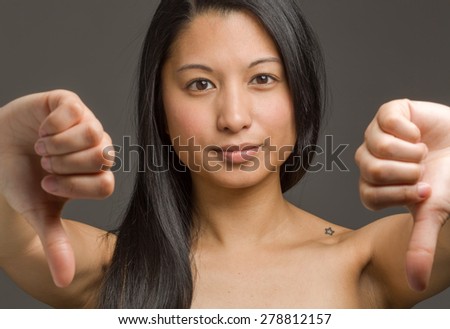Model isolated on plain background in studio with thumbs down