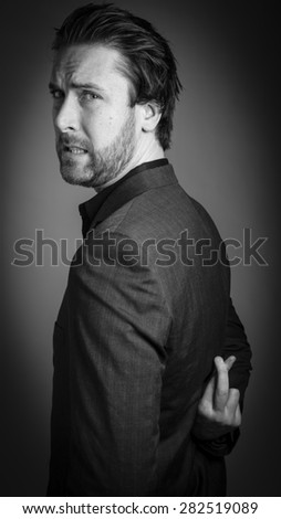 Attractive 30 years old caucasian man shot in studio isolated on a grey background, black and white image