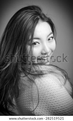 Attractive caucasian business woman in her 30s shot in studio isolated on a white background, black and white image in her 30s shot in studio isolated on a grey background, black and white image