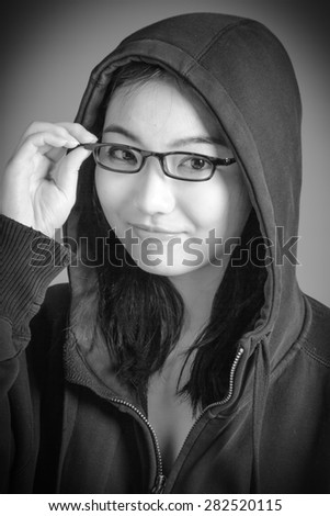 Attractive asian girl in her twenties isolated on a plain background, black and white image shot in a studio