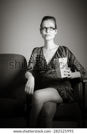 Attractive caucasian woman in the theatre in her 30 isolated on a grey background, black and white image