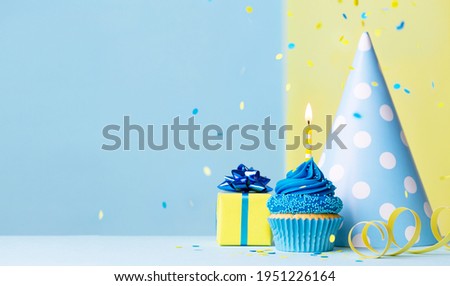 Birthday cupcake background with birthday gift, birthday party hat and falling confetti